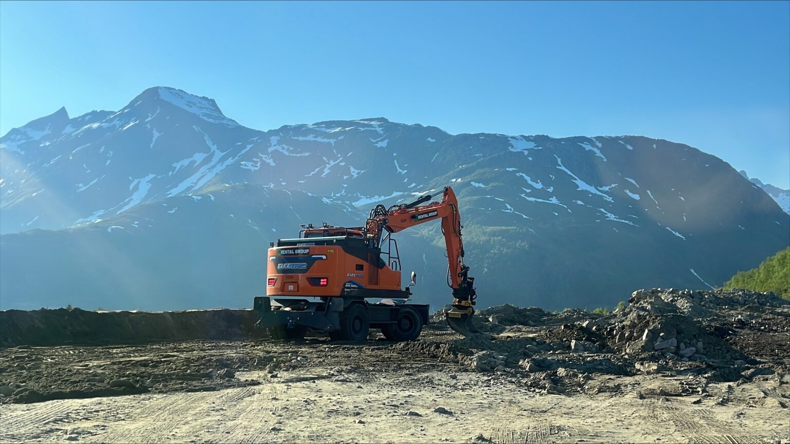 Elektrisk hjulgraver fra Rental Group jobber på en anleggsplass med fjell i bakgrunnen